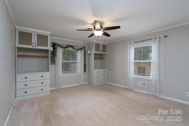 a view of empty room with cabinet and chandelier fan