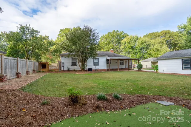 a front view of a house with a yard and trees