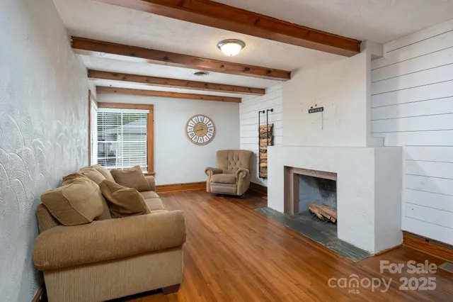 a living room with furniture a fireplace and a window