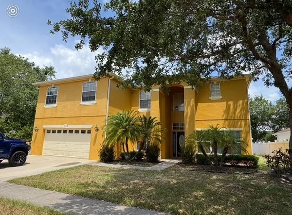 a view of a house with a yard and tree s