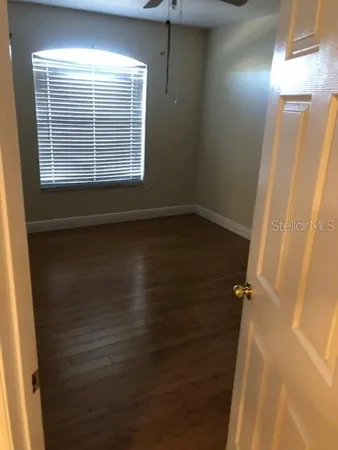 a view of a room with wooden floor and a window