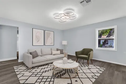 a living room with furniture and a painting on the wall