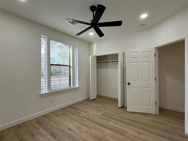 a view of room with hardwood floor and a ceiling fan