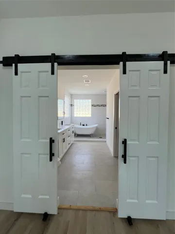 a view of a hallway with wooden floor windows and a cabinet