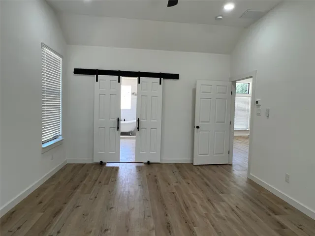 an empty room with wooden floor and windows