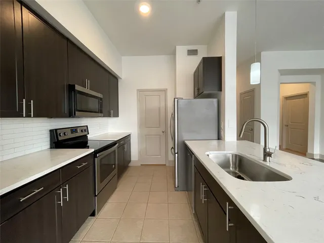 a kitchen with stainless steel appliances a sink stove and refrigerator