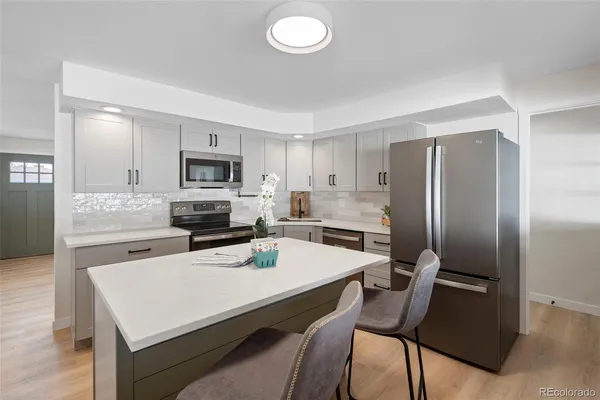 a kitchen with a sink a stove top oven and white cabinets