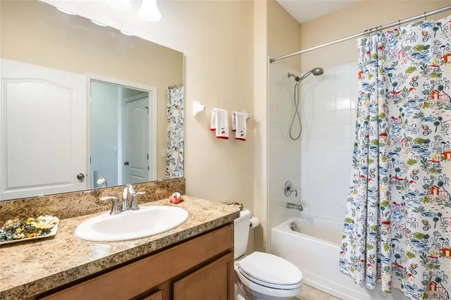 a bathroom with a granite countertop sink toilet bathtub and shower