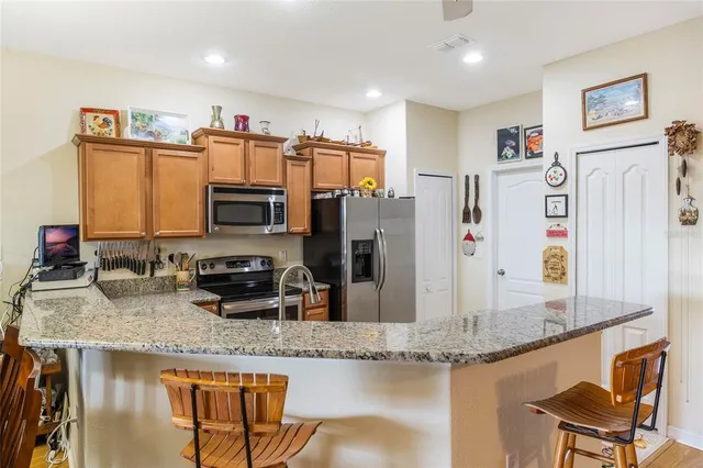 a kitchen with stainless steel appliances granite countertop a sink refrigerator and cabinets