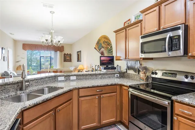 a kitchen with stainless steel appliances granite countertop a sink stove and microwave