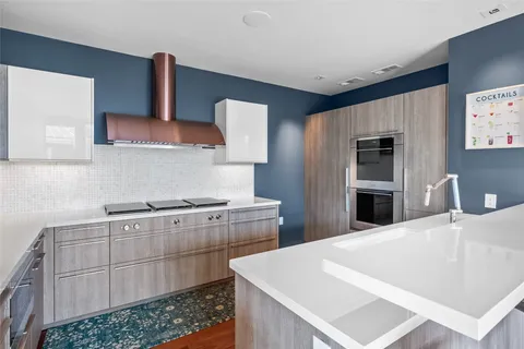 a kitchen with granite countertop stainless steel appliances a sink window and cabinets