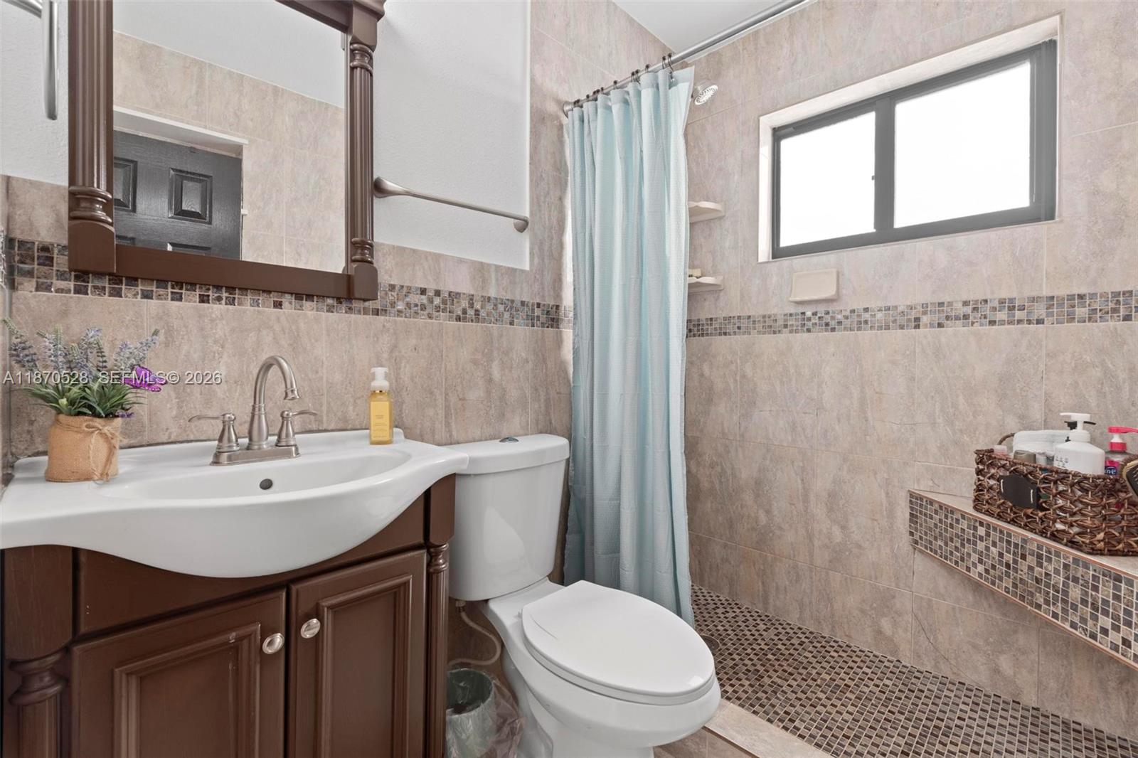 6539 Southwest 84th Avenue Miami, FL 33143 - Photo 23 of 26 a bathroom with a sink toilet a mirror and shower