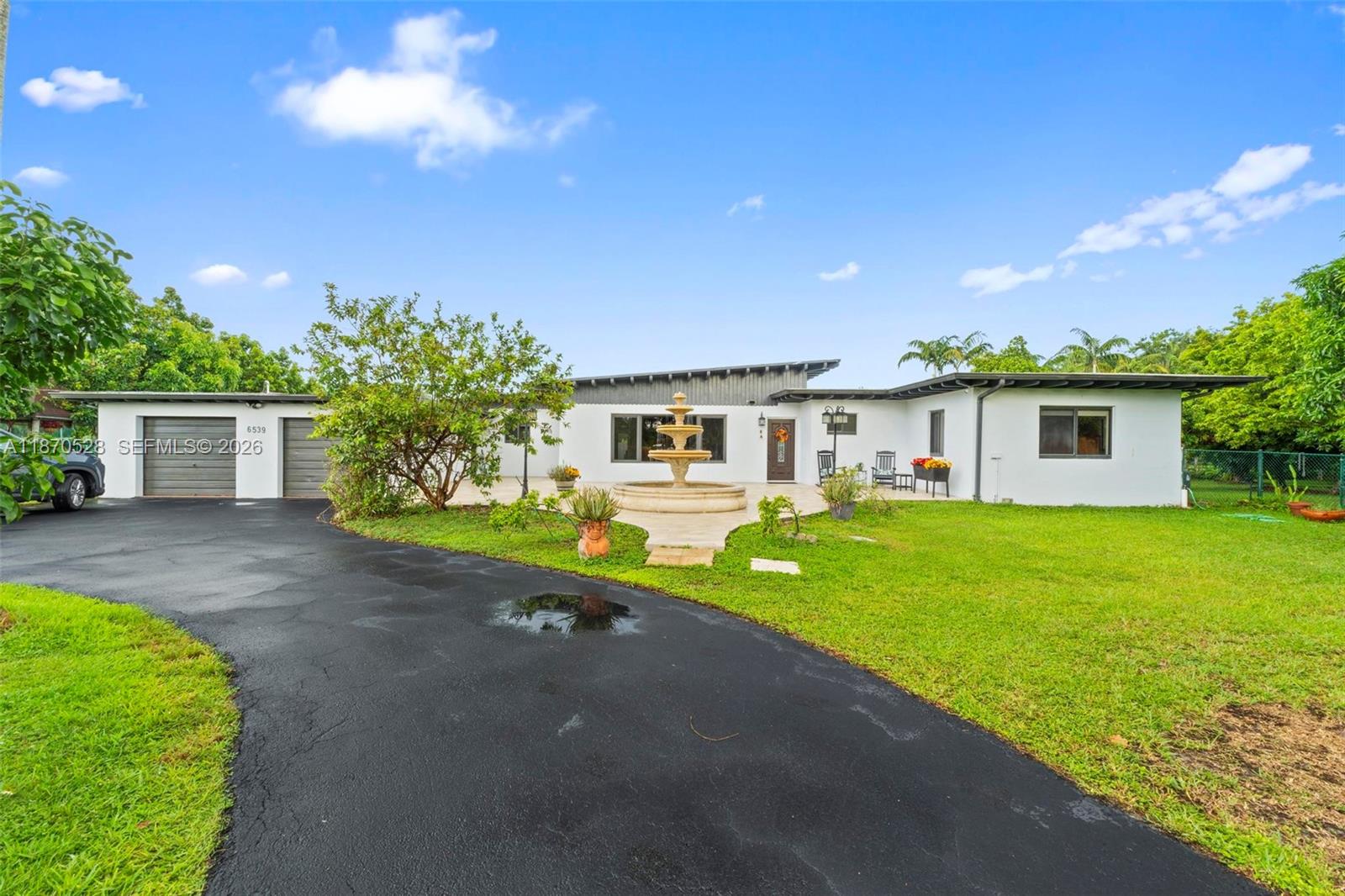 6539 Southwest 84th Avenue Miami, FL 33143 - Photo 4 of 25 a front view of a house with a yard and garage