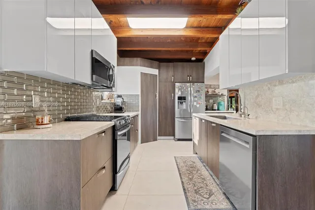 a kitchen with stainless steel appliances granite countertop a sink a stove a microwave and a refrigerator