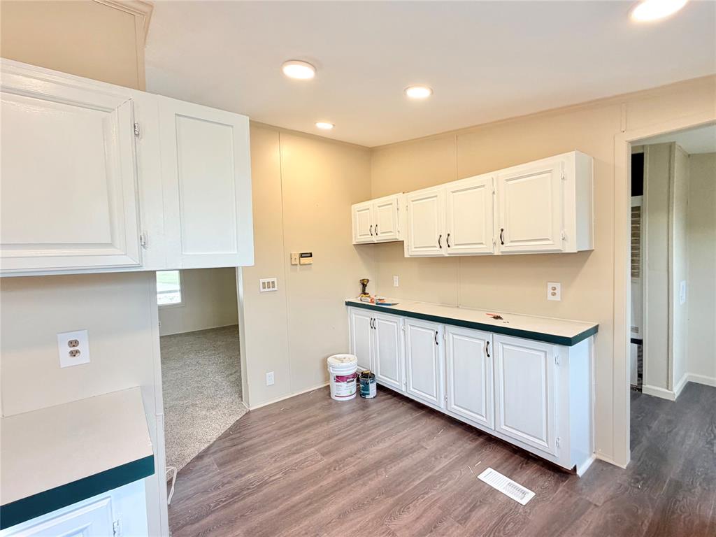 9721 Limestone Joshua, TX 76058 - Photo 18 of 36 a kitchen with granite countertop white cabinets and a wooden floor
