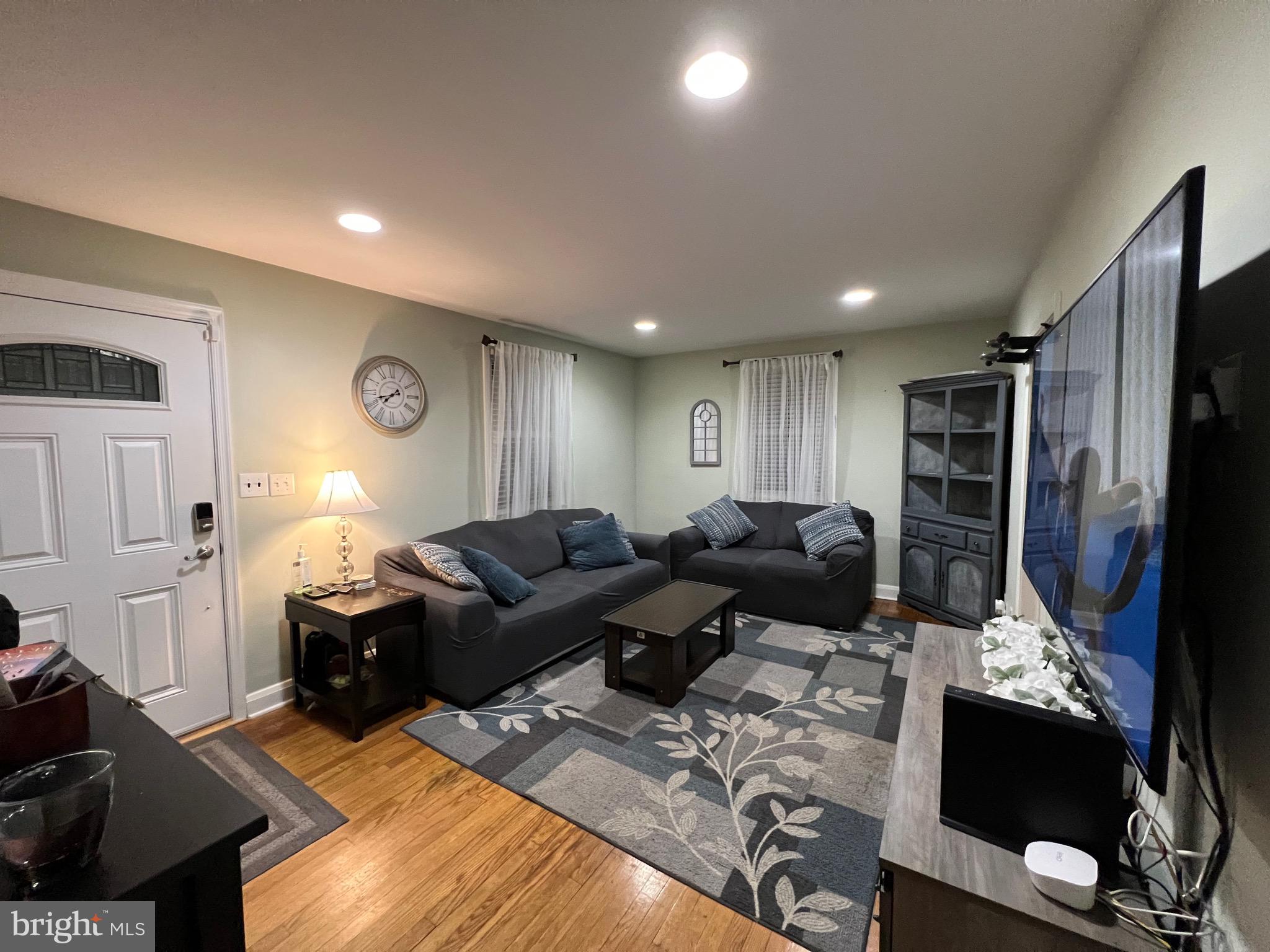 8111 Hillendale Road Baltimore, MD 21234 - Photo 3 of 21 a living room with furniture a flat screen tv and a refrigerator