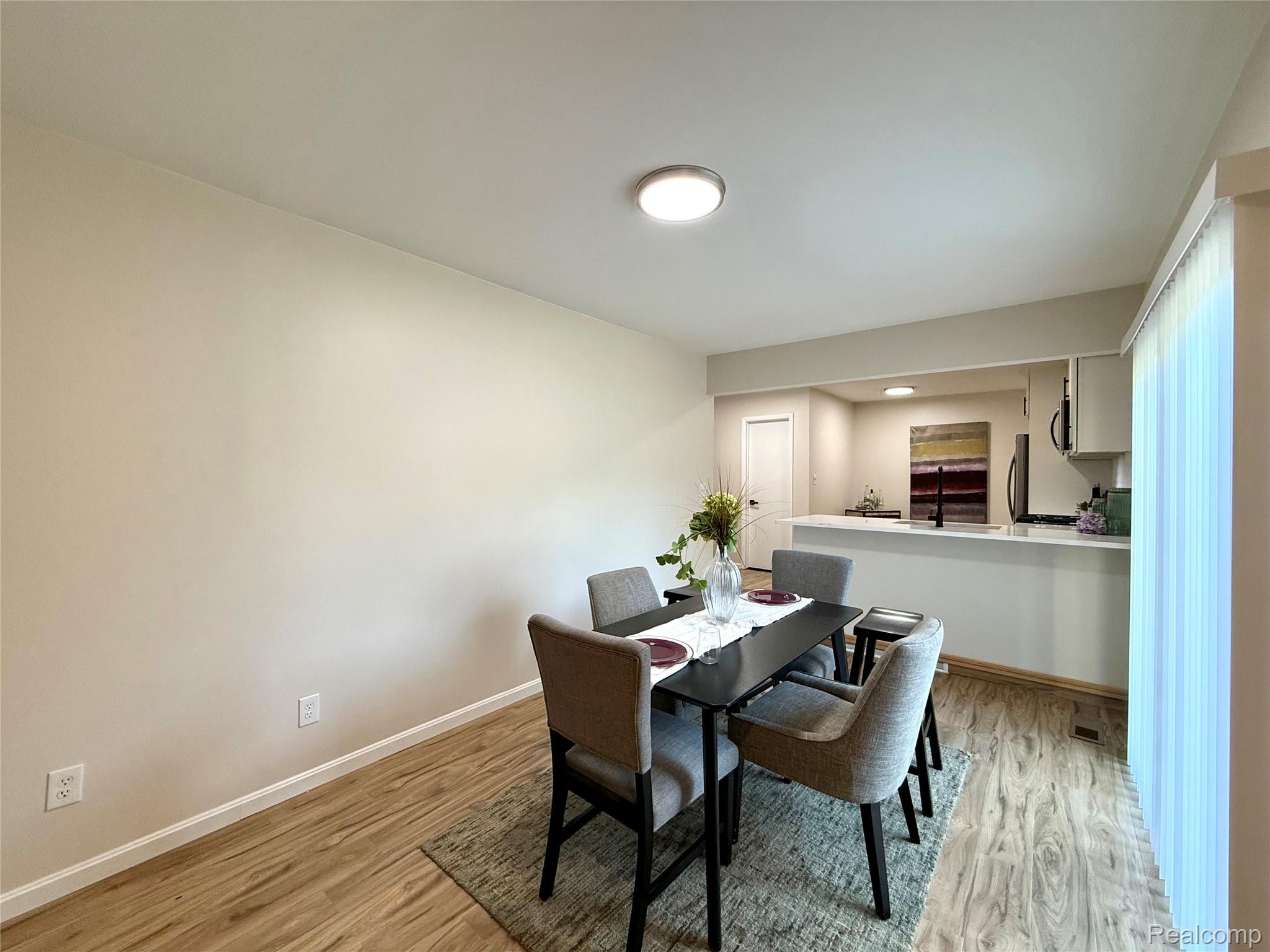 39909 Lynn Street Canton, MI 48187 - Photo 12 of 45 Dining area featuring wood-finish flooring, neutral wall tones, and an overhead flush-mount light fixture