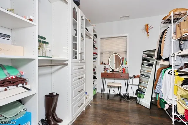 a view of walk in closet with clothes and shoes