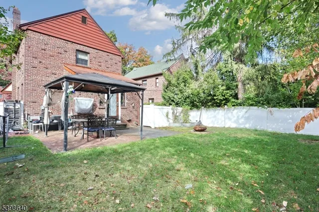 a view of a chair and table in backyard of the house