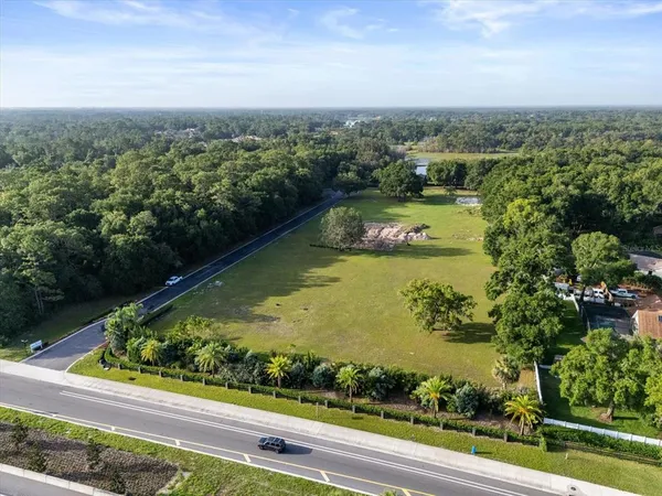 an aerial view of residential houses with outdoor space and lake view