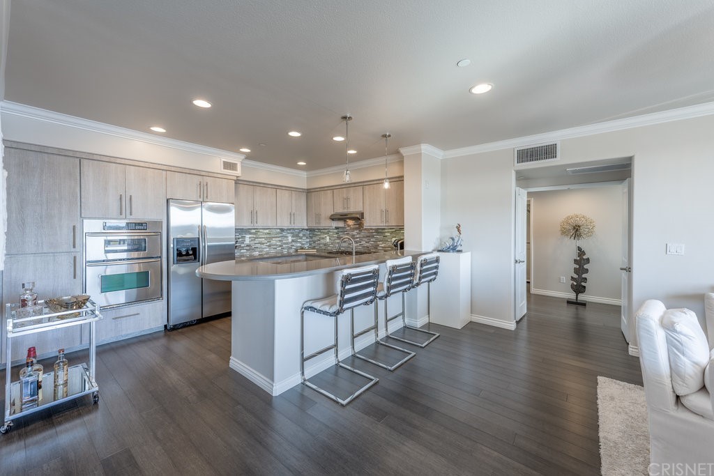 4346 Tradewinds Drive Oxnard, CA 93035 - Photo 7 of 35 a kitchen with stainless steel appliances granite countertop a refrigerator oven a sink dishwasher and white cabinets with wooden floor