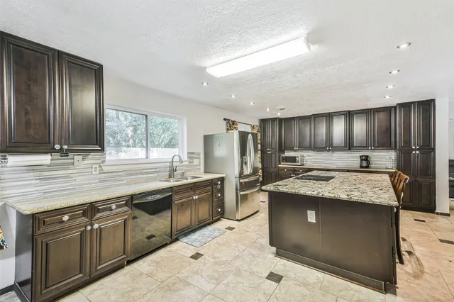 a kitchen with stainless steel appliances granite countertop counter space a sink and cabinets