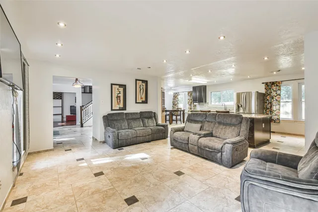 a living room with furniture and a view of kitchen