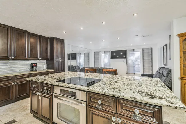a kitchen with stainless steel appliances granite countertop a sink stove and cabinets