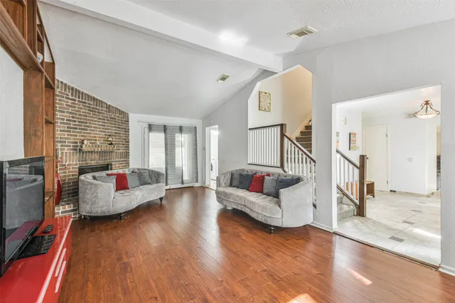 a living room with fireplace furniture and a wooden floor