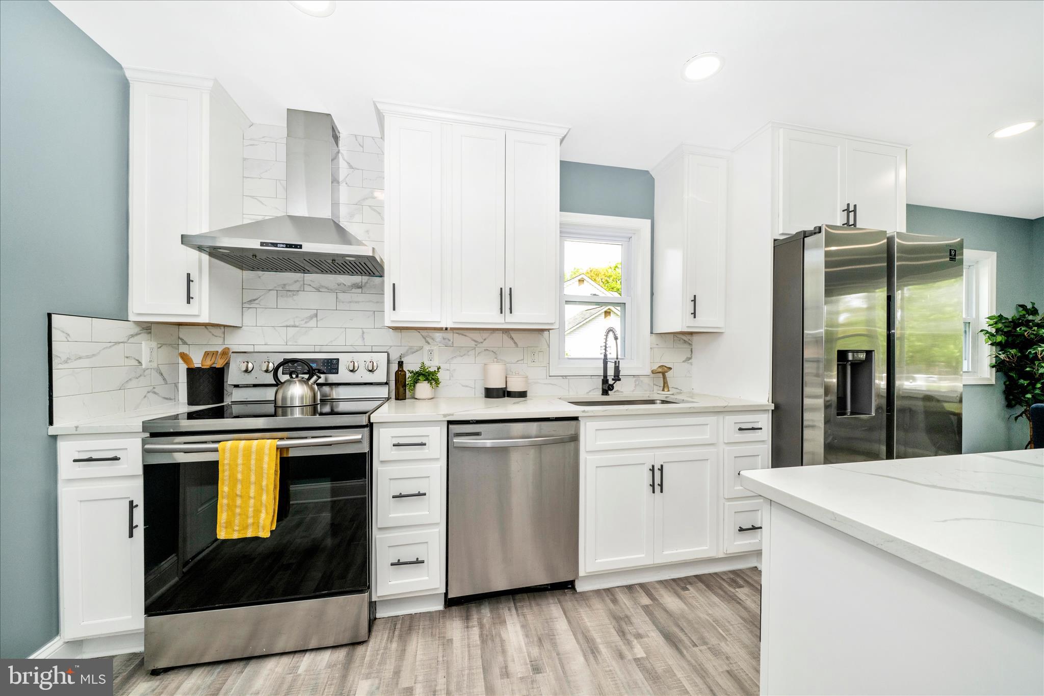 6737 Allentown Road Temple Hills, MD 20748 - Photo 28 of 51 a kitchen with stainless steel appliances granite countertop a stove and white cabinets