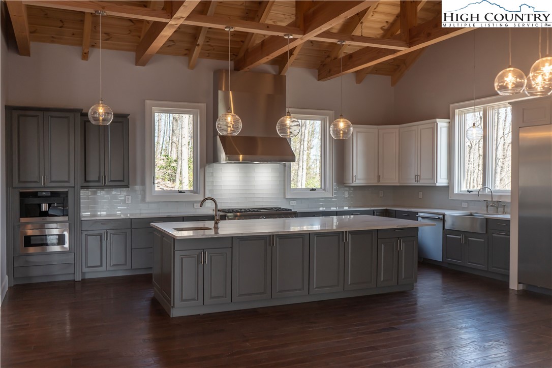 280 Boulder Cay Road Boone, NC 28607 - Photo 12 of 33 a kitchen with stainless steel appliances granite countertop a sink stove and wooden floor