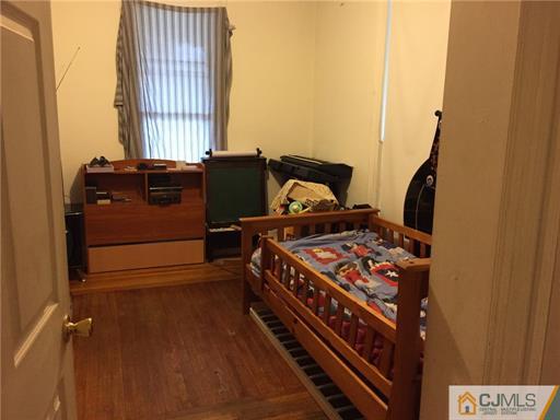 333 New Market Road Dunellen, NJ 08812 - Photo 4 of 19 a bed sitting in a bedroom next to a window