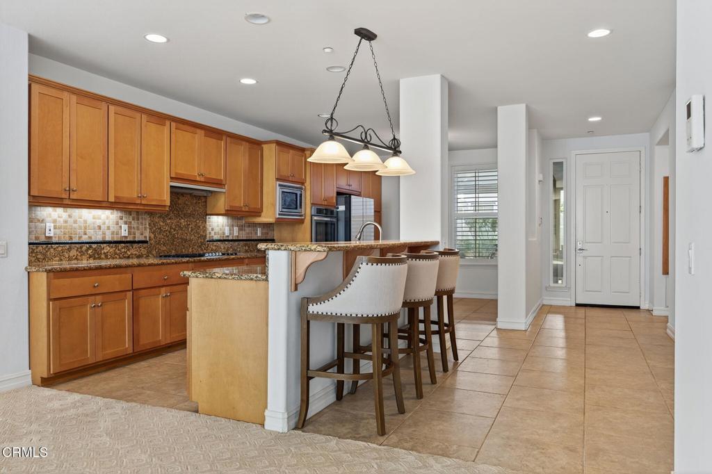 1423 Windshore Way Oxnard, CA 93035 - Photo 21 of 77 a kitchen with stainless steel appliances granite countertop a stove top oven a sink a counter top space cabinets and a dining table