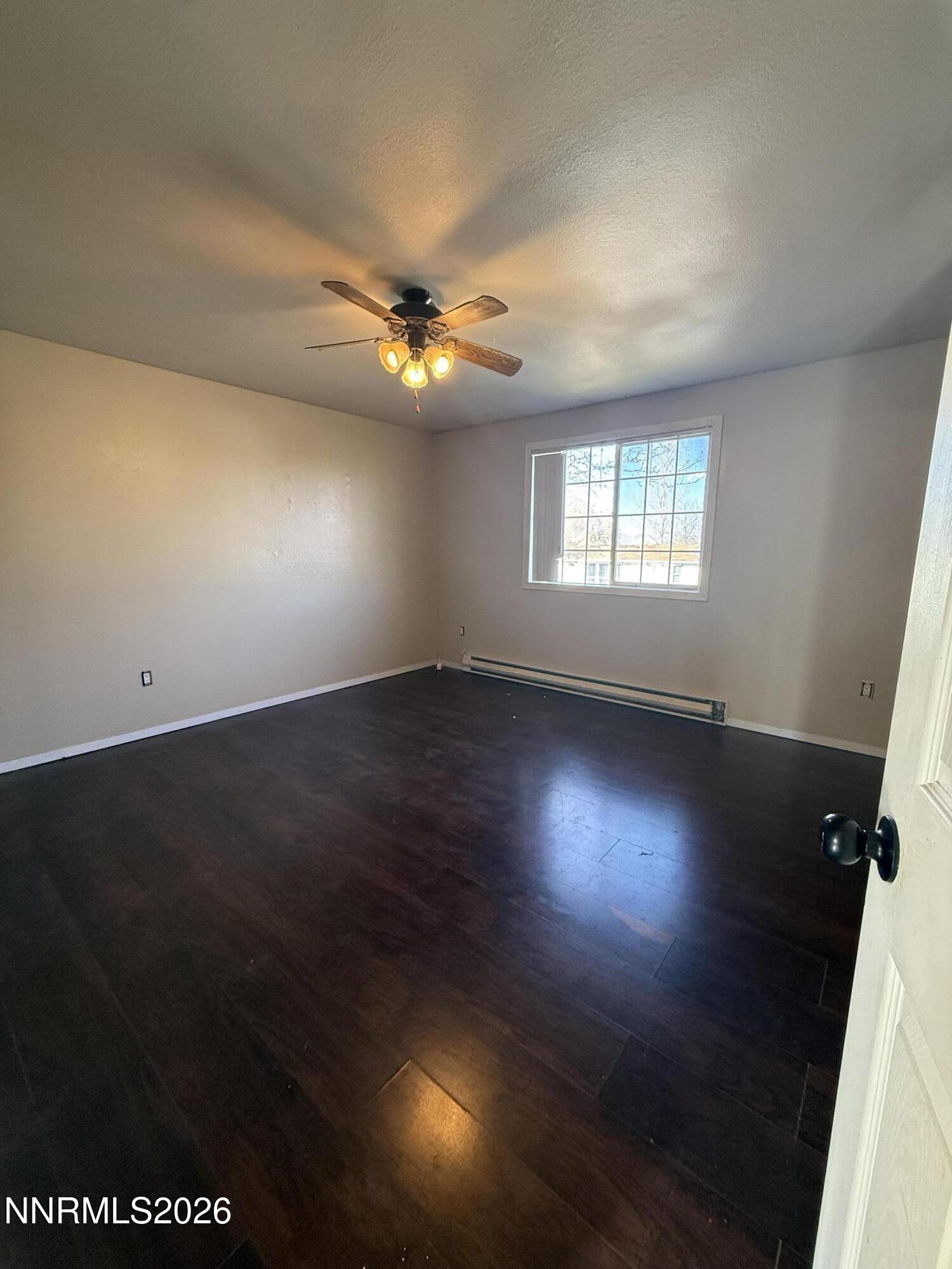 1362 Kodac Street Winnemucca, NV 89445 - Photo 13 of 21 an empty room with wooden floor and windows