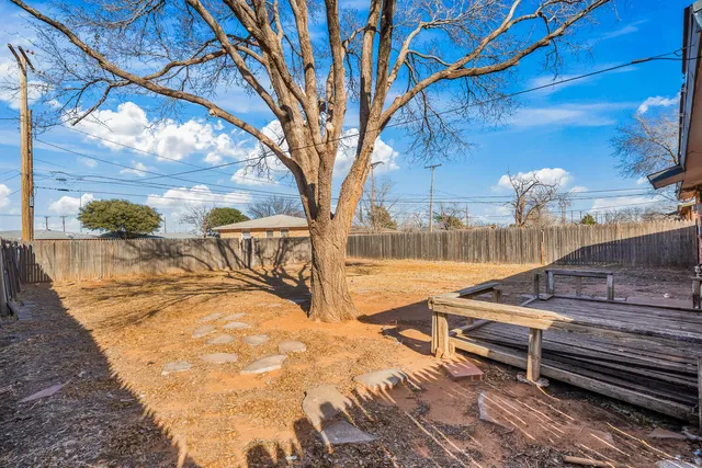 a view of a backyard with wooden fence