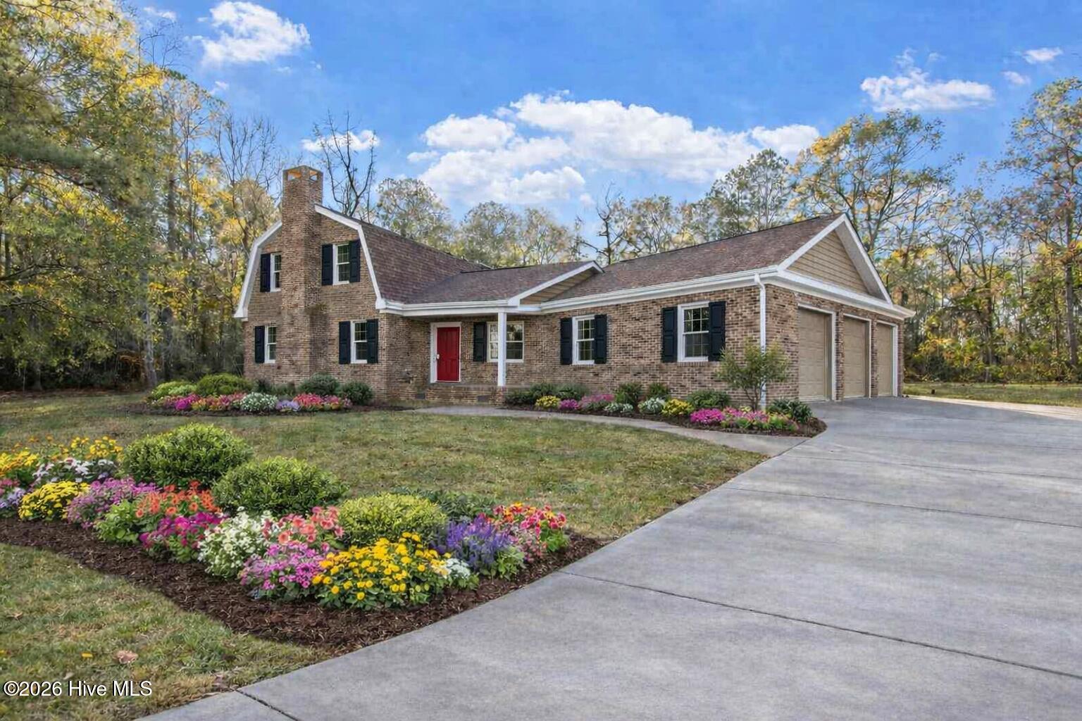 50 Irvin Enzor Road South Fair Bluff, NC 28439 - Photo 2 of 31 AI enhanced exterior w/shutters, paint, flowers, driveway