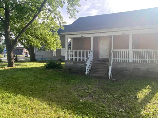 a view of a house with backyard and a tree