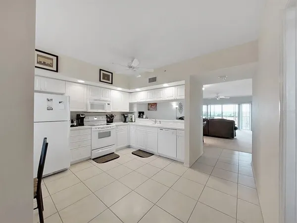 a large white kitchen with cabinets and stainless steel appliances