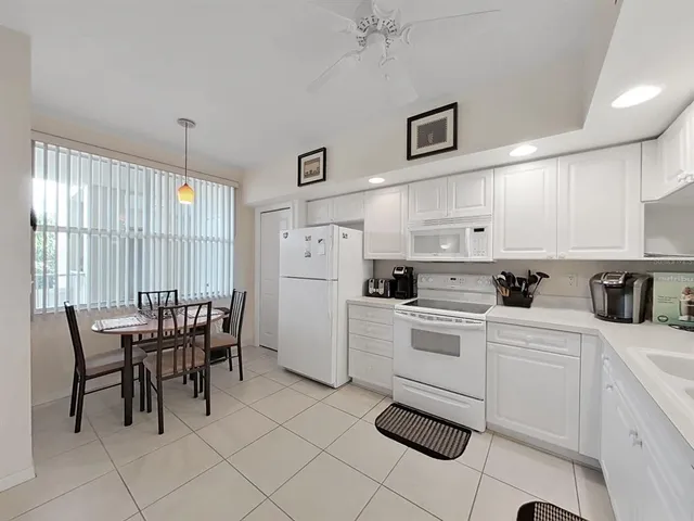 a kitchen with white cabinets and white appliances