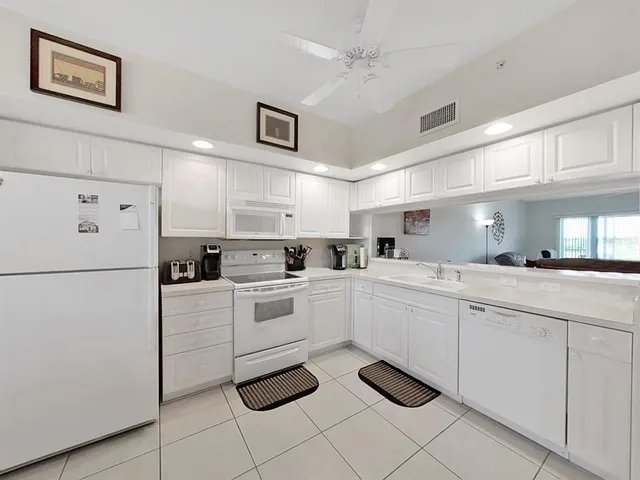 a kitchen with white cabinets and white appliances