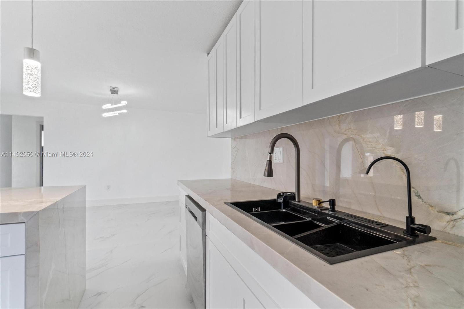 15951 Southwest 42nd Terrace Miami, FL 33185 - Photo 11 of 40 a close view of a sink and dishwasher with kitchen island
