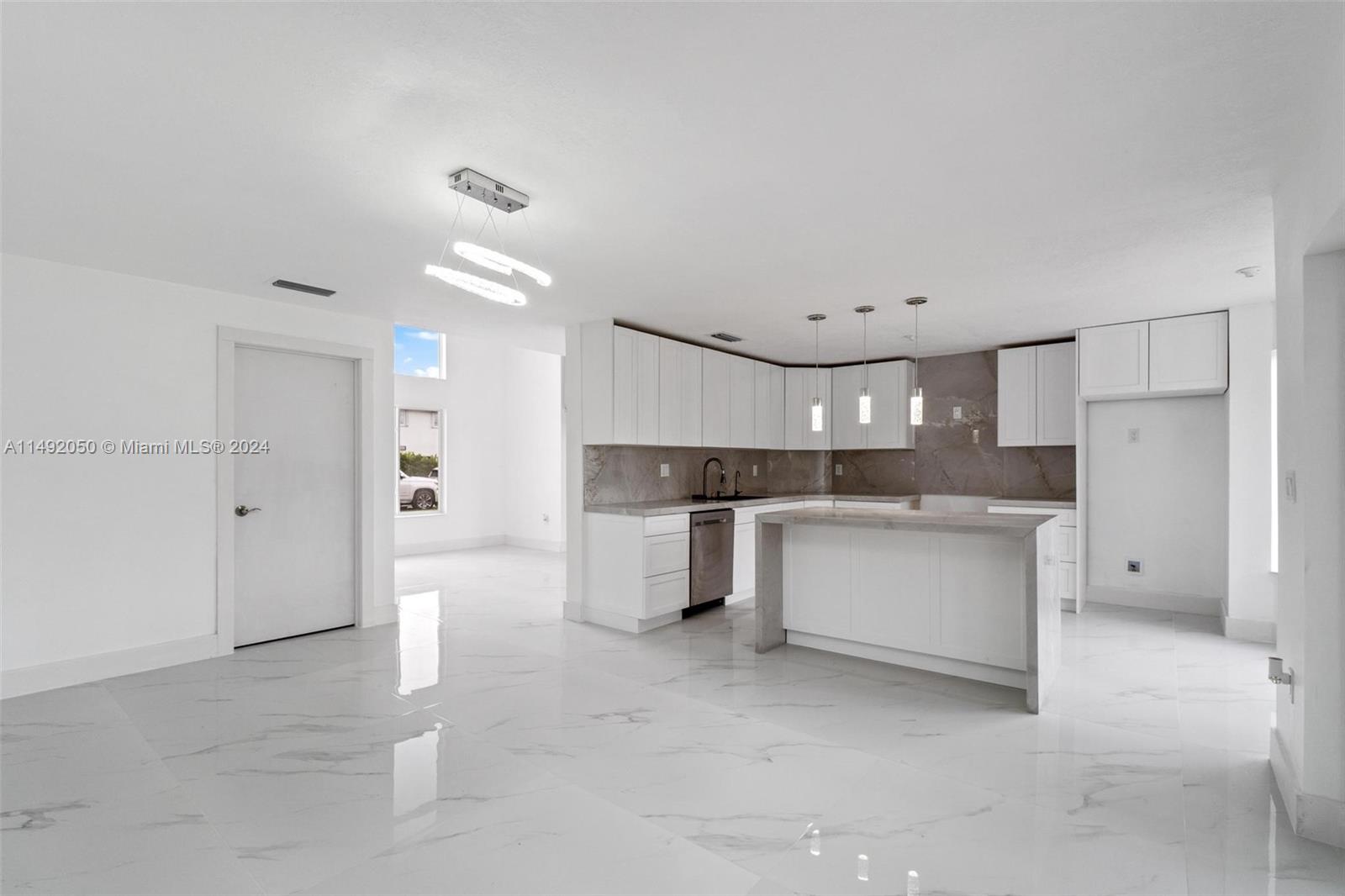 15951 Southwest 42nd Terrace Miami, FL 33185 - Photo 6 of 40 a large white kitchen with a stove a sink dishwasher and a refrigerator with wooden floor