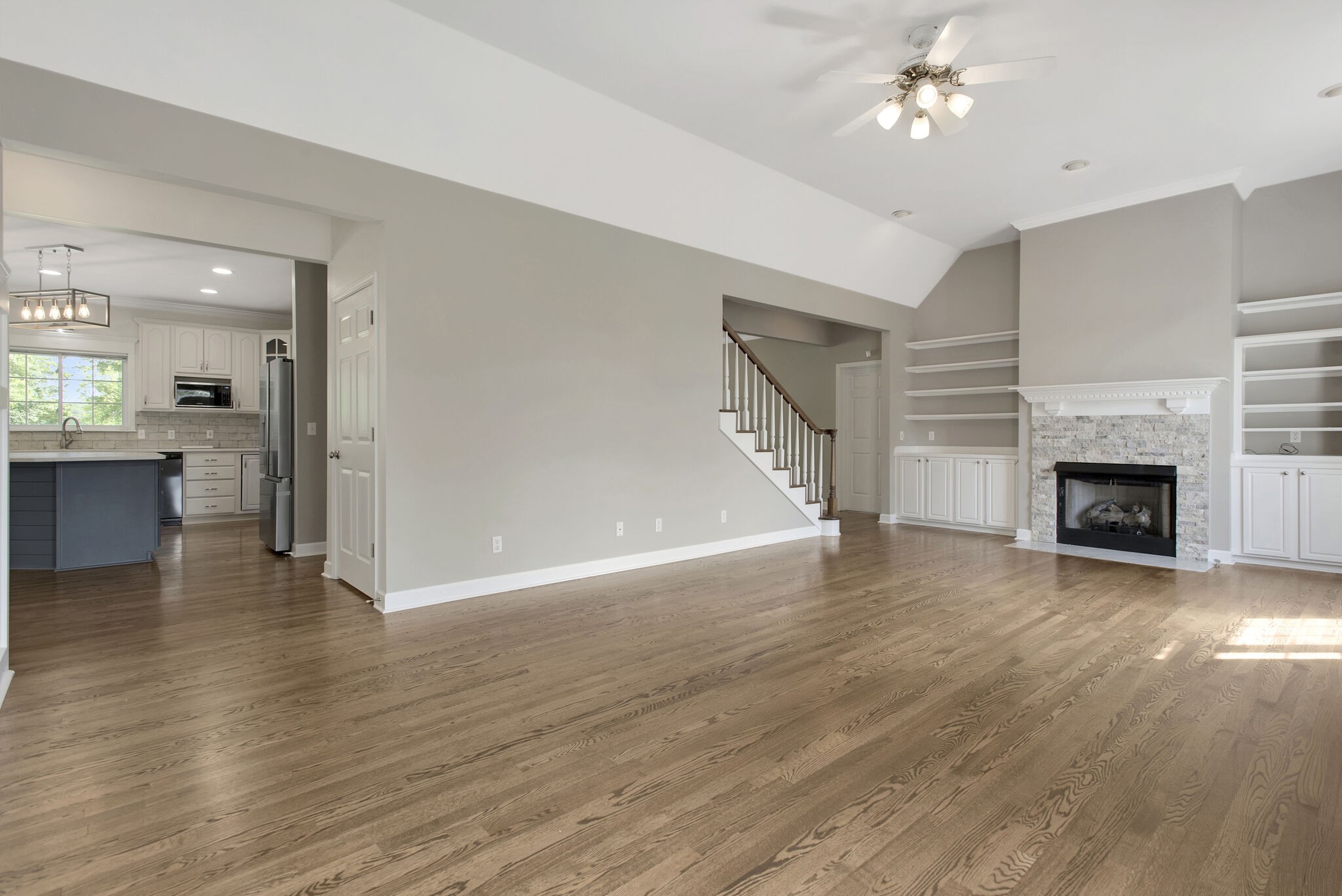 1576 Old Hillsboro Road Franklin, TN 37069 - Photo 12 of 66 a view of a livingroom with wooden floor a ceiling fan a fireplace and entryway