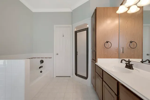 an empty room with a window and a chandelier fan