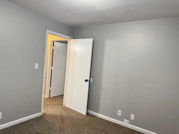 an empty room with closet and mirror