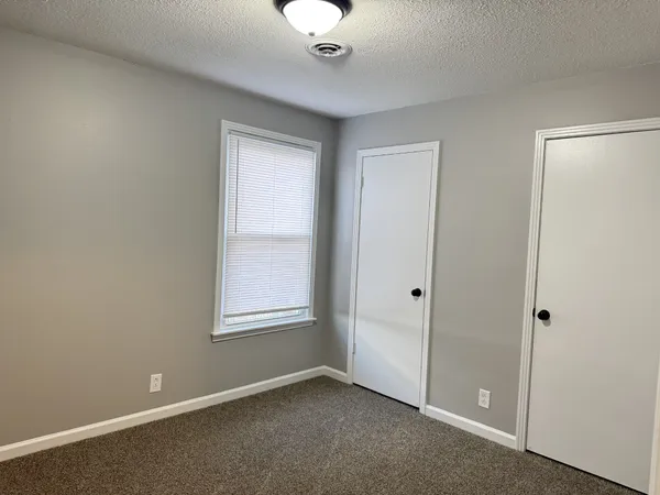 an empty room with windows and closet