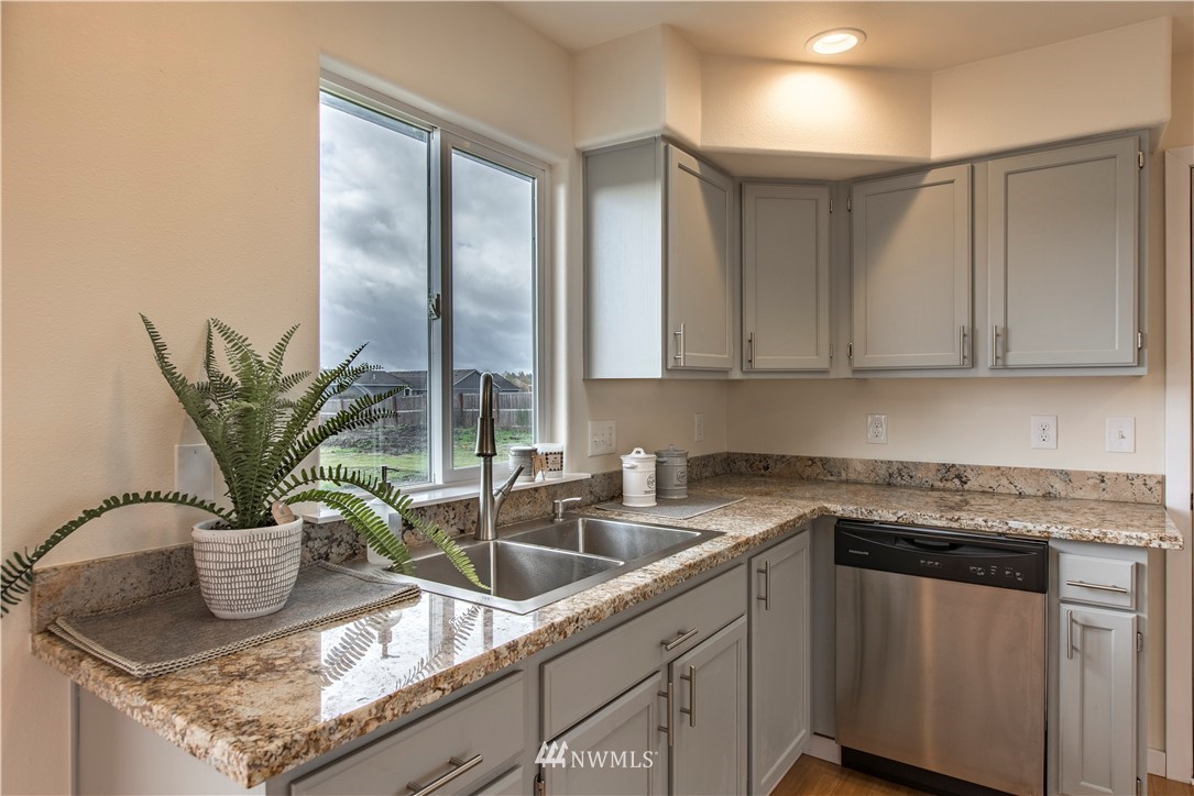 4425 180th Way Southwest Rochester, WA 98579 - Photo 22 of 25 a kitchen with stainless steel appliances granite countertop a sink and a white cabinets
