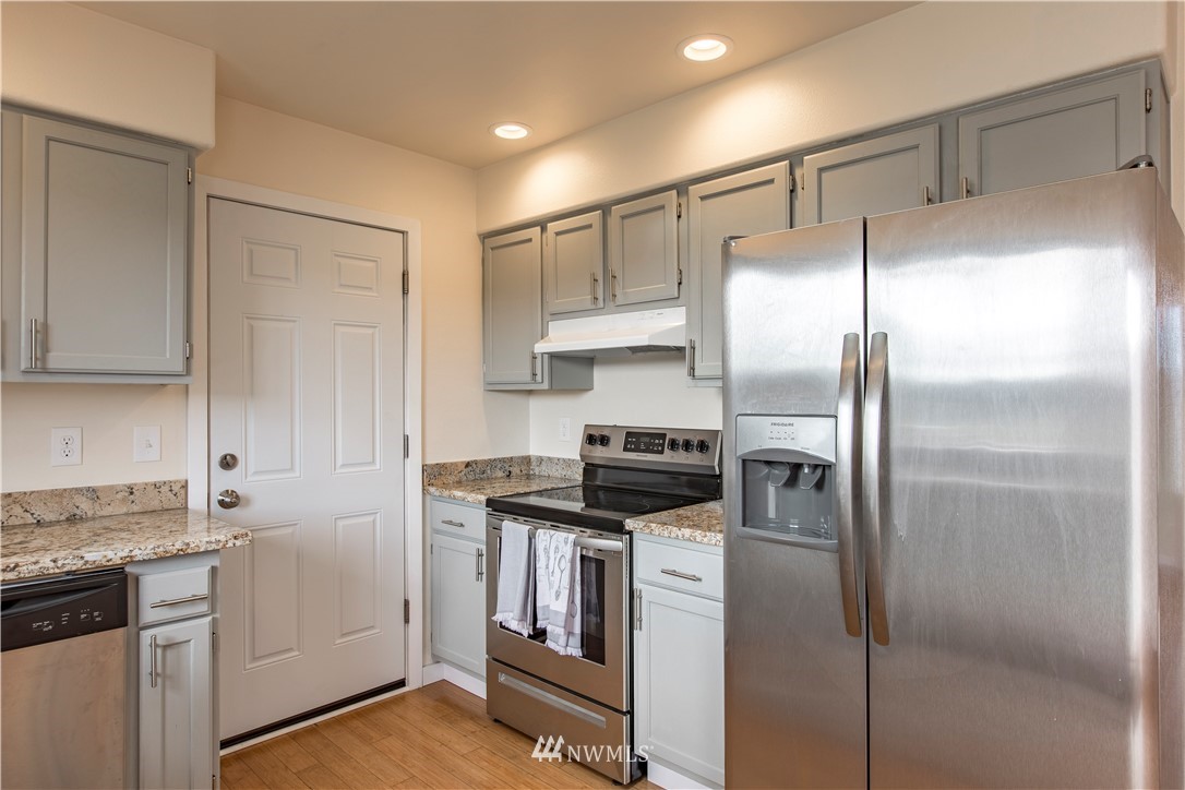 4425 180th Way Southwest Rochester, WA 98579 - Photo 23 of 25 a kitchen with a refrigerator a sink and cabinets