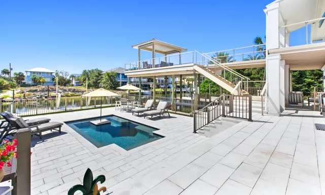 a view of a house with a yard and palm trees
