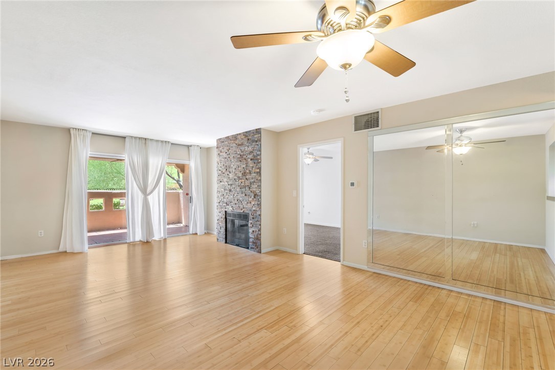 1901 Rio Canyon Court, Unit 102 Las Vegas, NV 89128 - Photo 7 of 23 Blonde wood flooring and a stone fireplace create an inviting space.